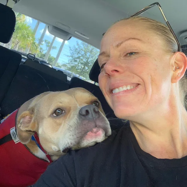 Jenn and a pup taking a selfie in the car